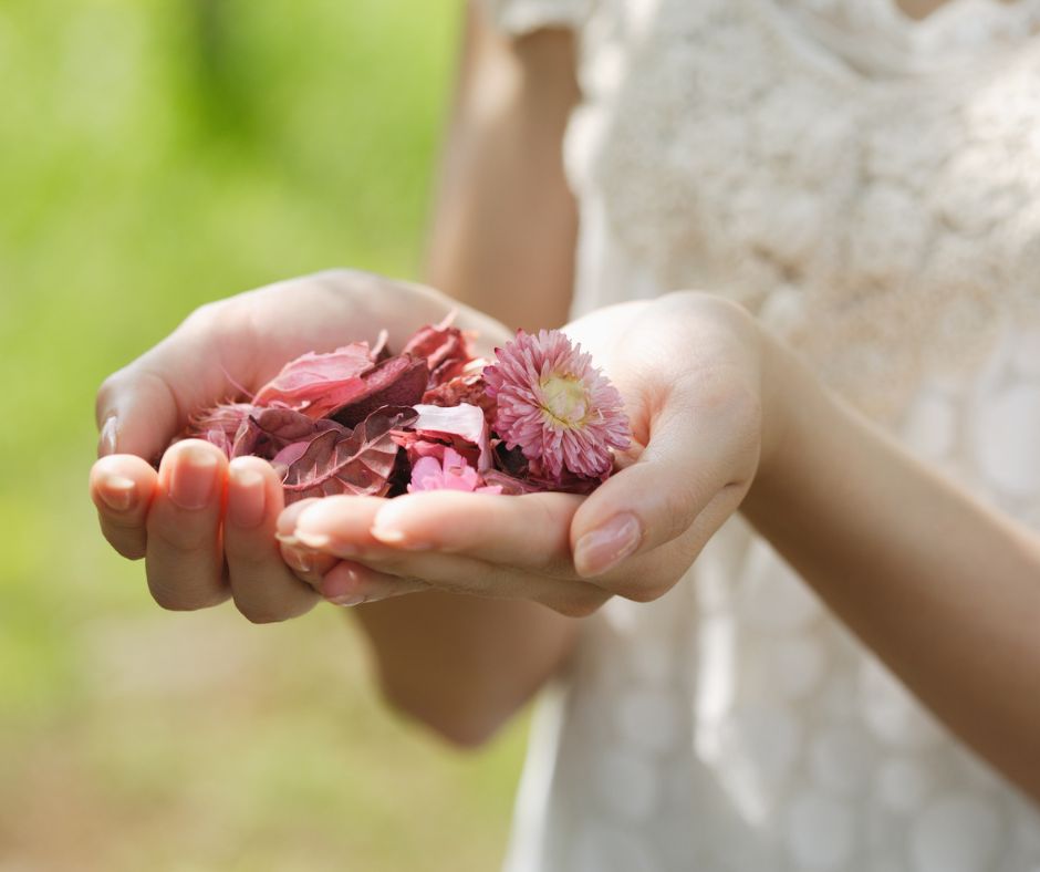 Offene Hände mit Blütenblättern – Symbol für Selbstfürsorge und Hoffnung bei Endometriose und Kinderwunsch.